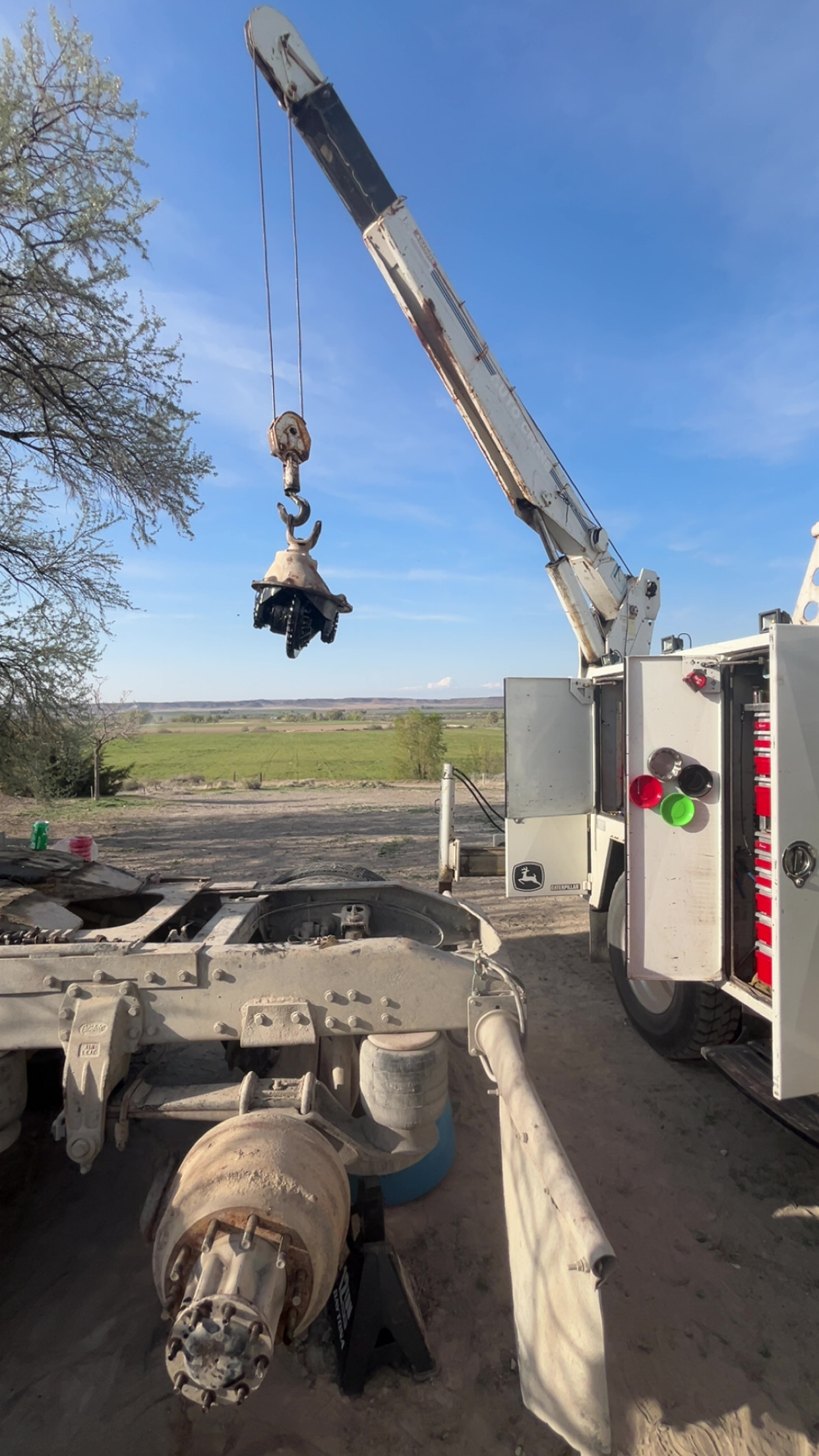 Crane lifting a differential during a field repair